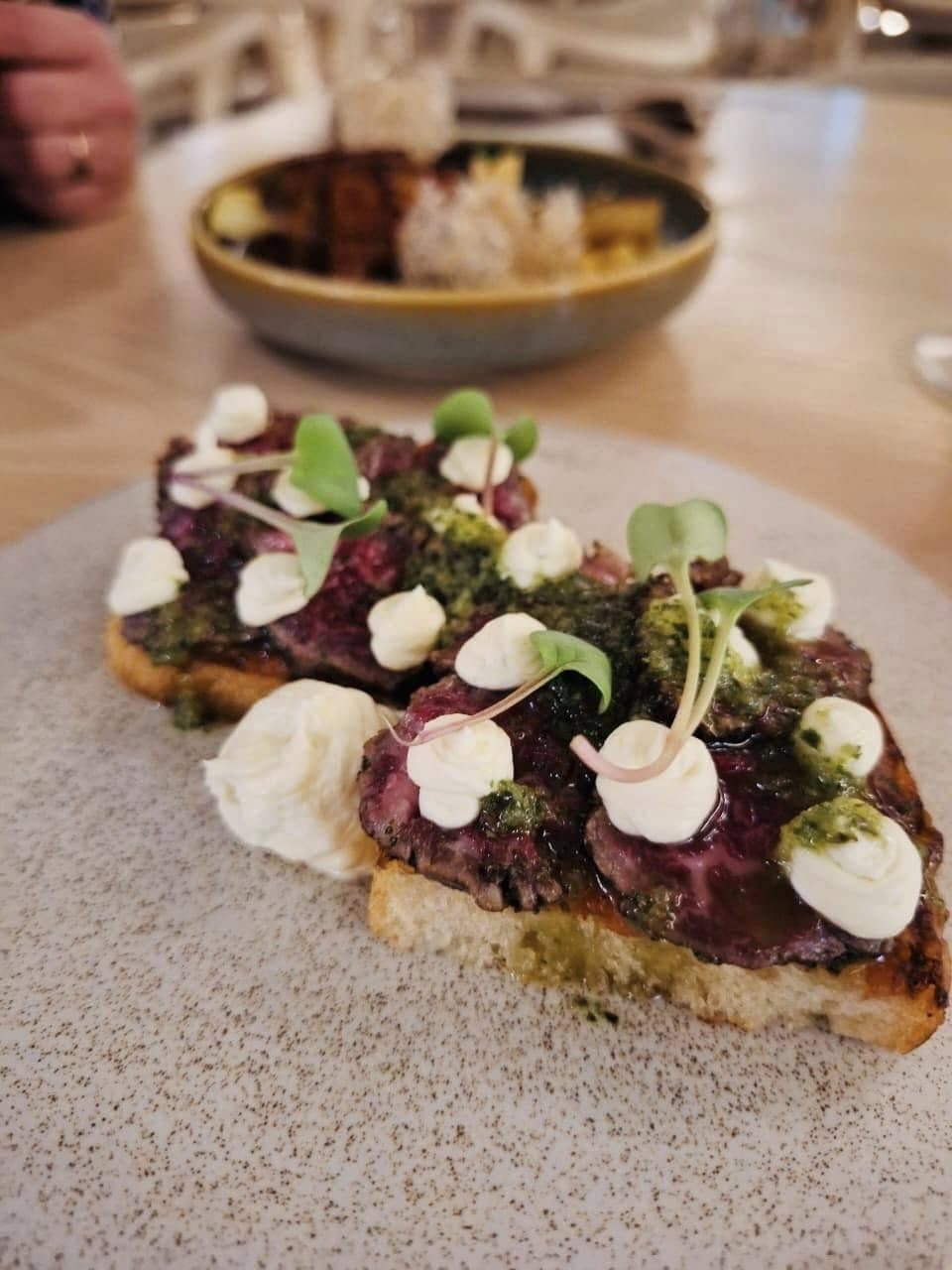 Bruschetta topped with beetroot, whipped cheese and micro herbs