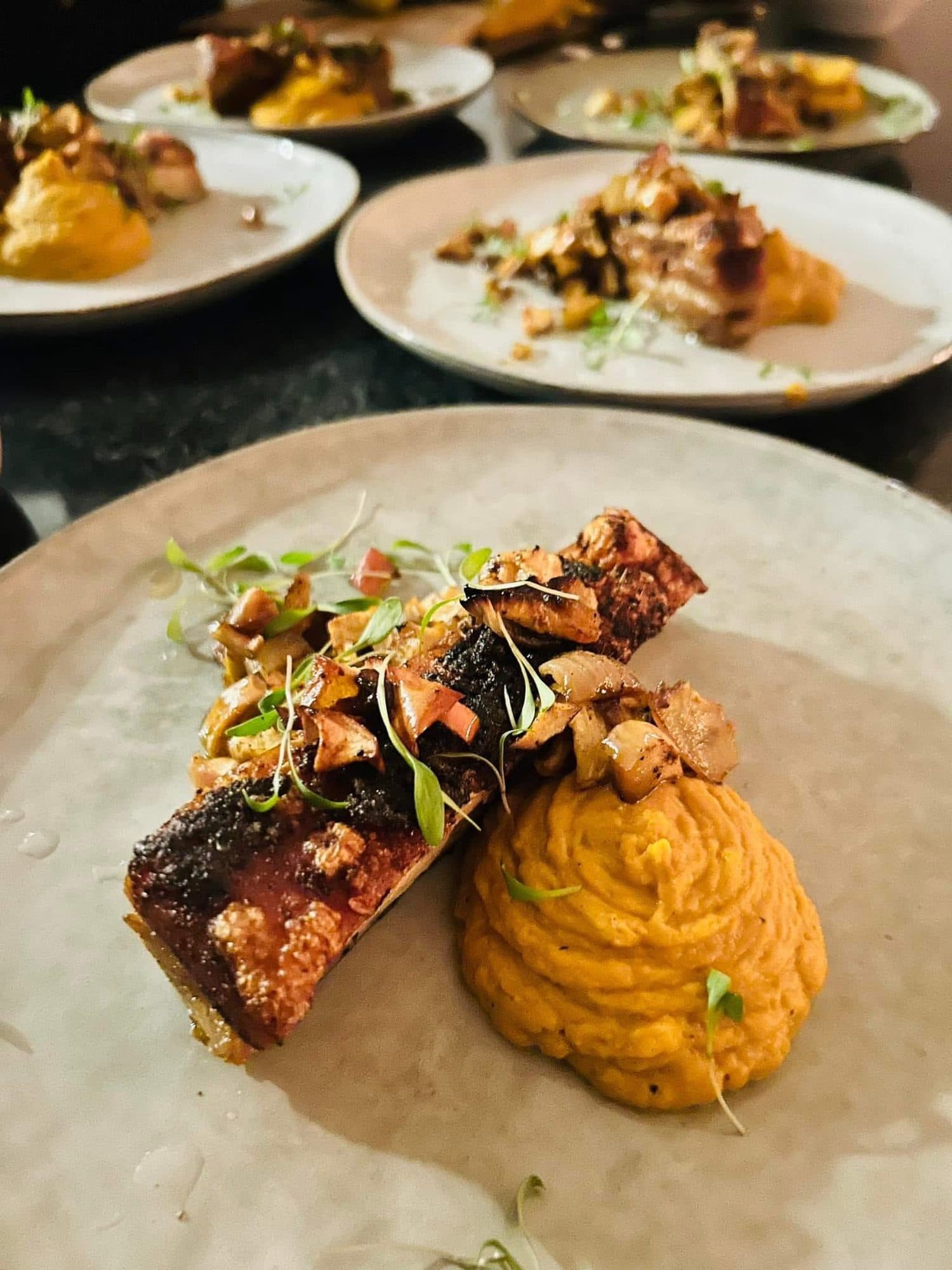 Crisp-skinned belly with a piped sweet-potato purée and fresh garnish