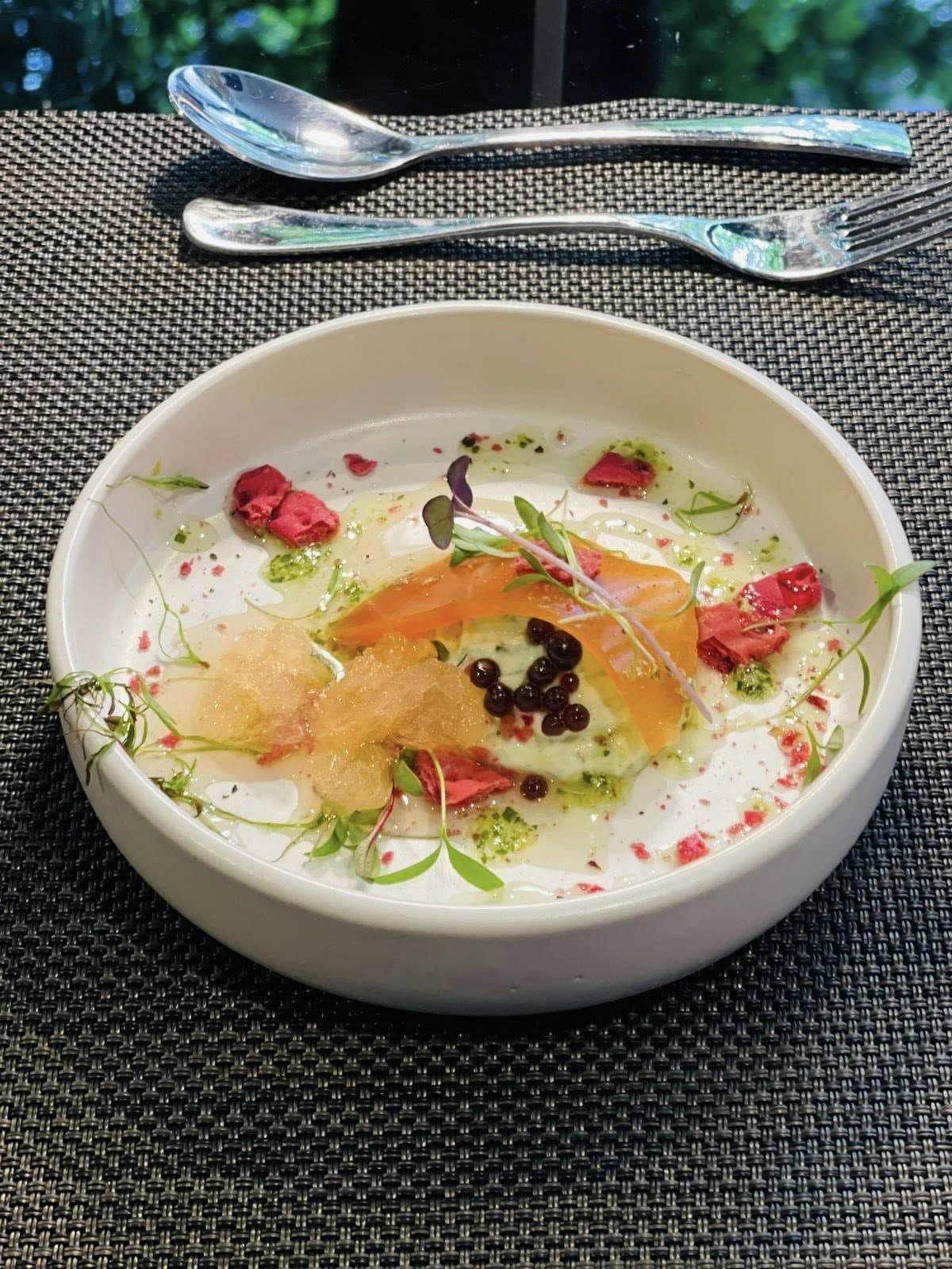 Cured fish in a chilled broth with berries and herbs