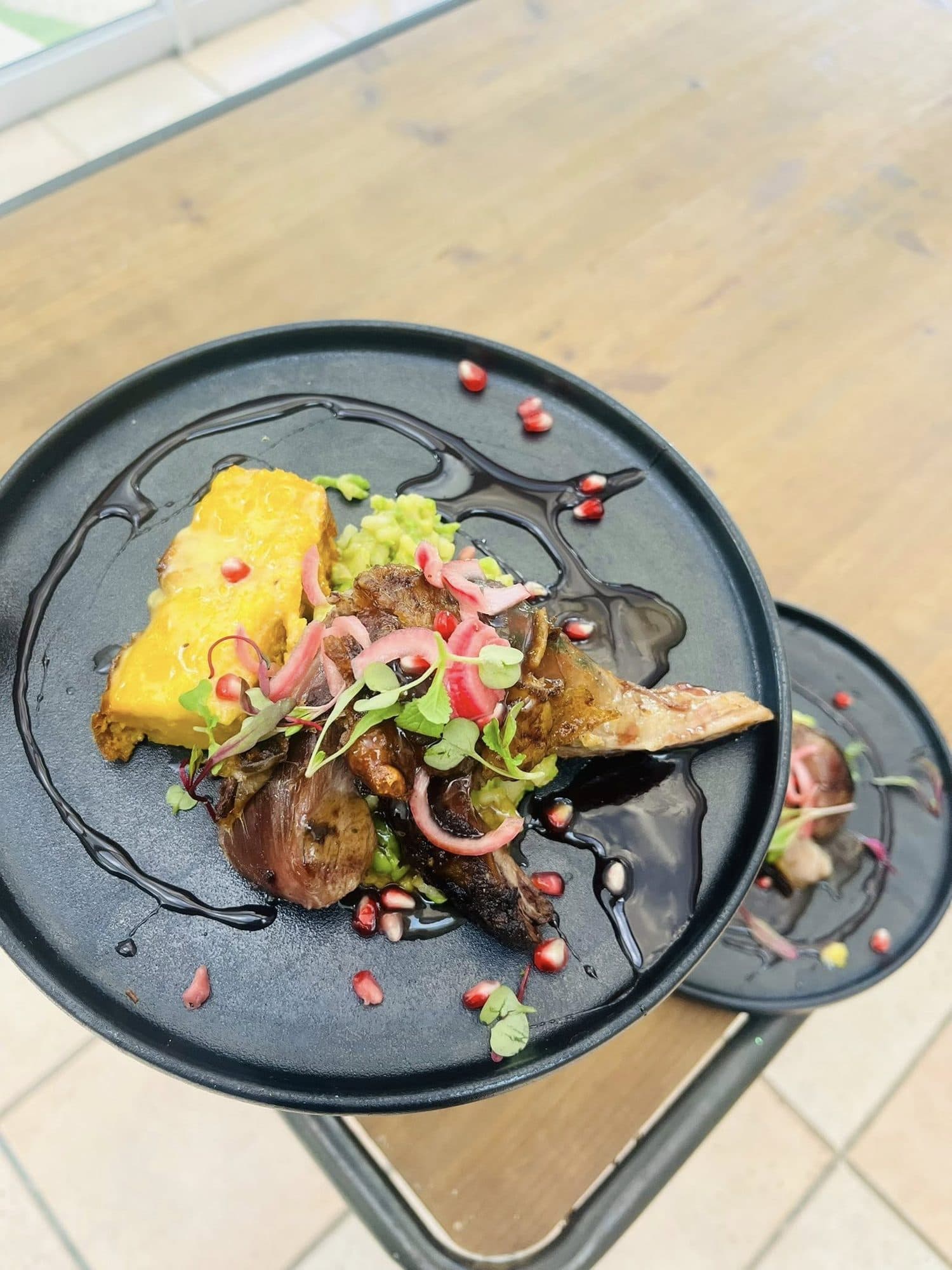 Plated dish with fresh salad on a dark plate