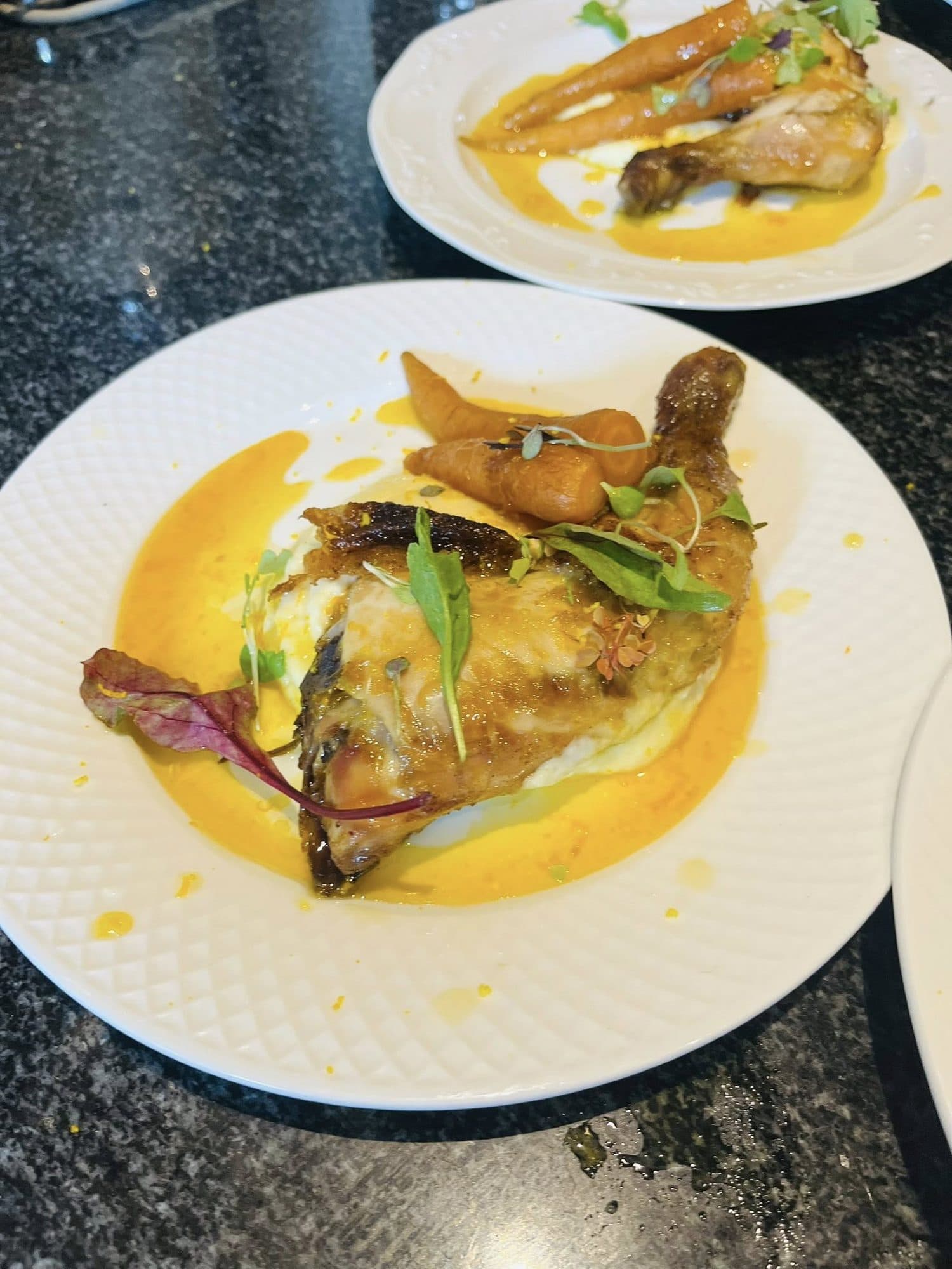 Plated main course with a bright golden sauce on a white plate