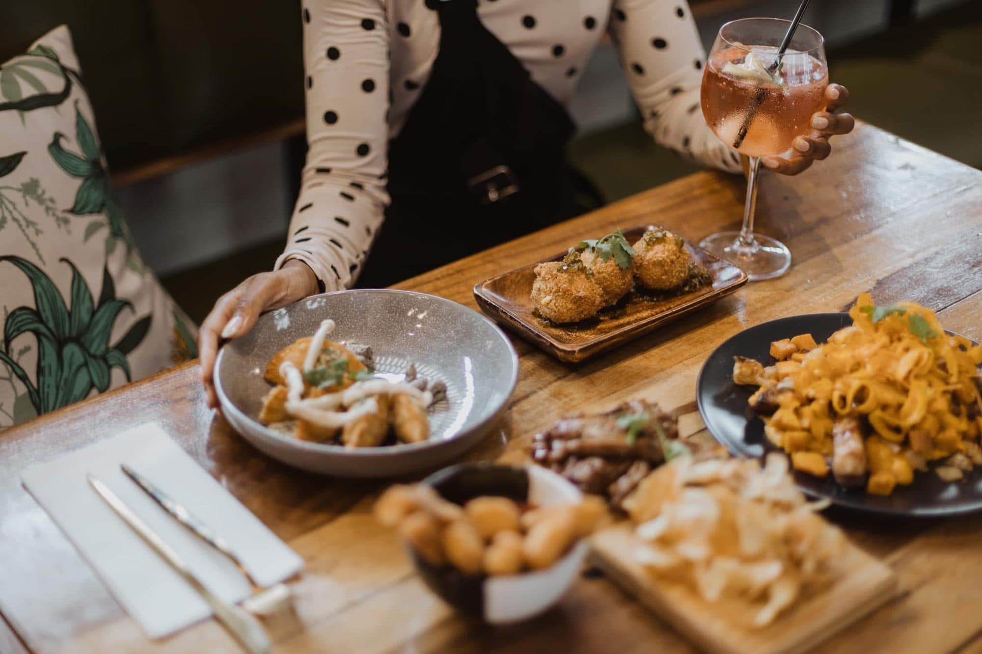 Guests reaching for shared dishes at a private dinner