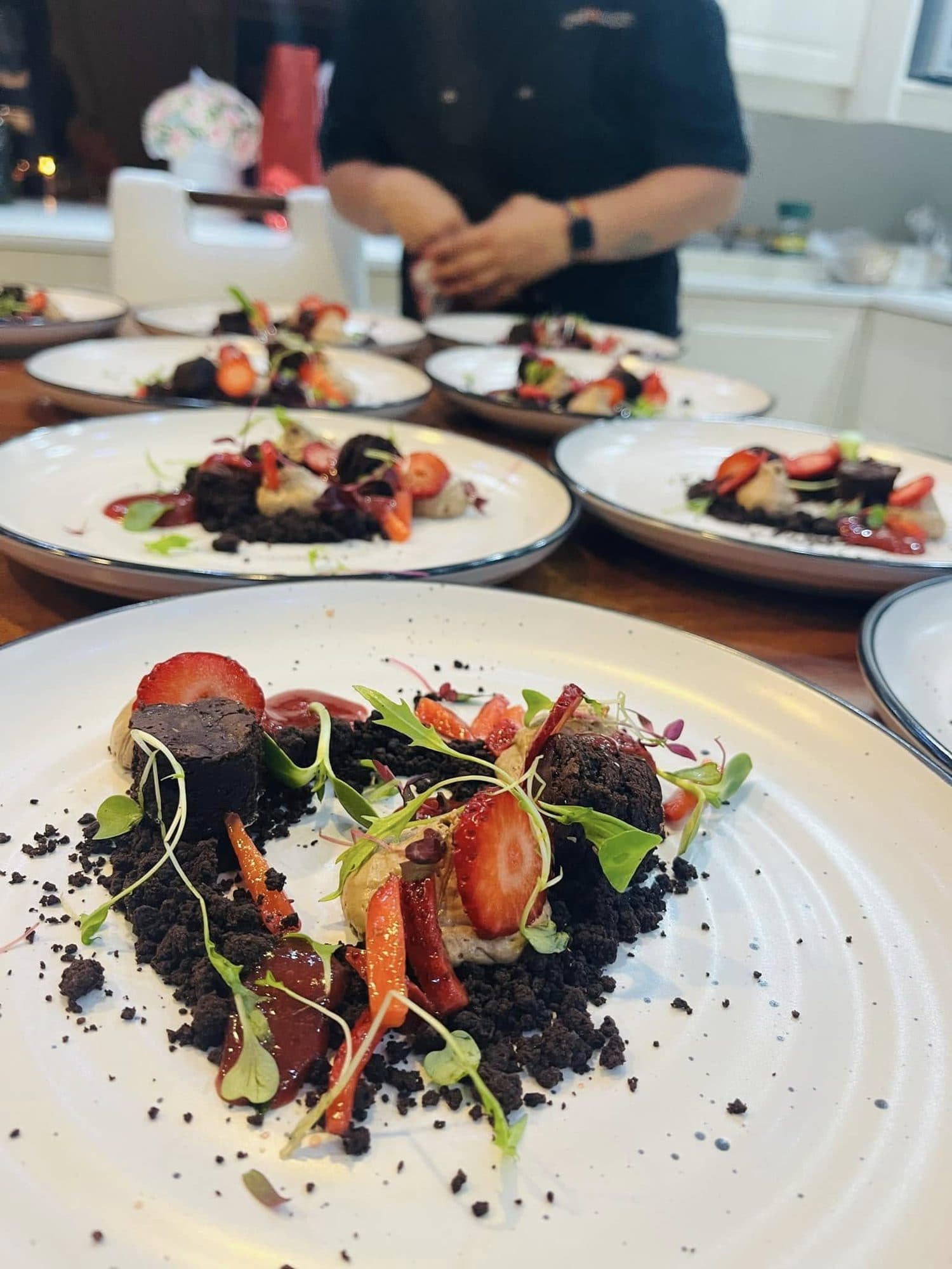 Plates of roasted beetroot, baby carrots and edible soil ready for service