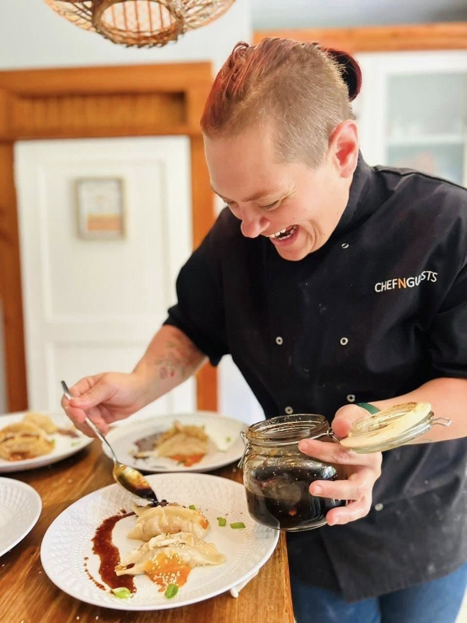 Chef Maradine laughing while plating a dish