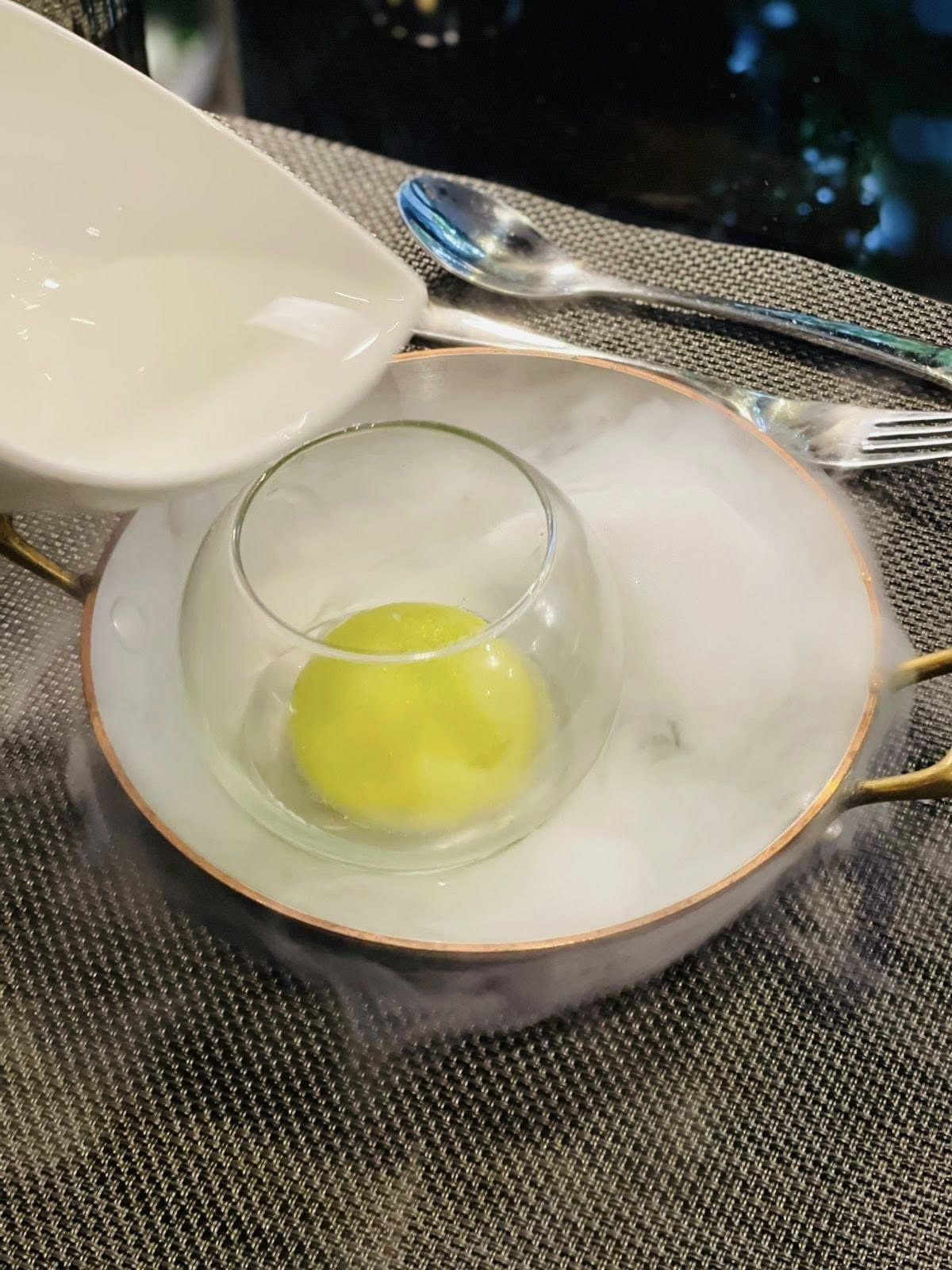 A theatrical course served in a glass surrounded by dry-ice mist