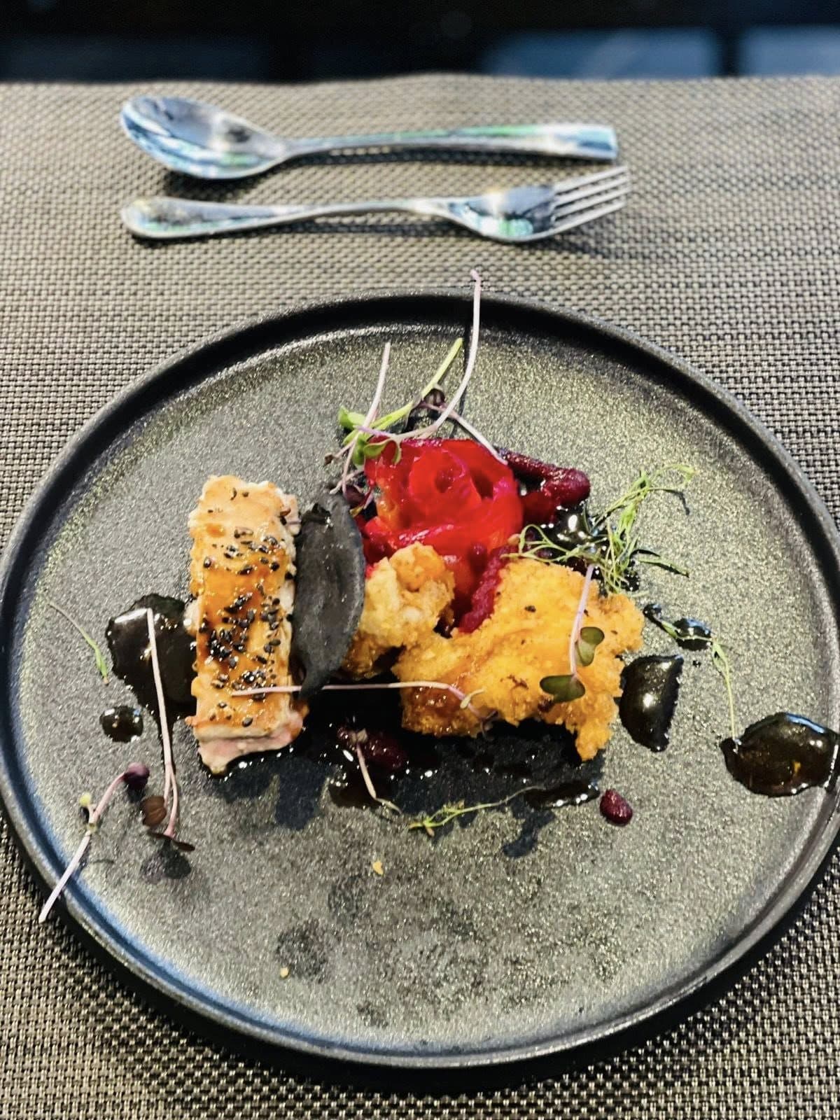 Fine-dining plate with seared fish, berries and a dark sauce