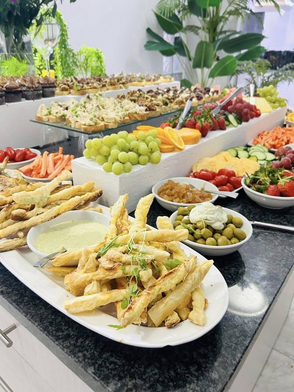 A grand buffet spread with fruit, crudités and hot dishes