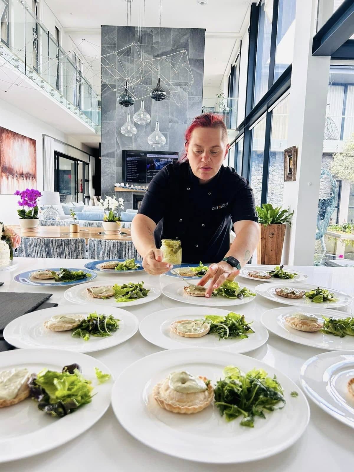 Chef Maradine plating a long row of starters in a private home