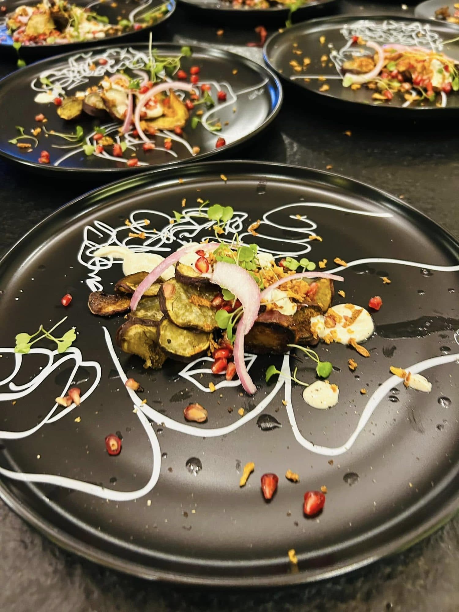 Starter plated on a black plate decorated with hand-drawn white line art