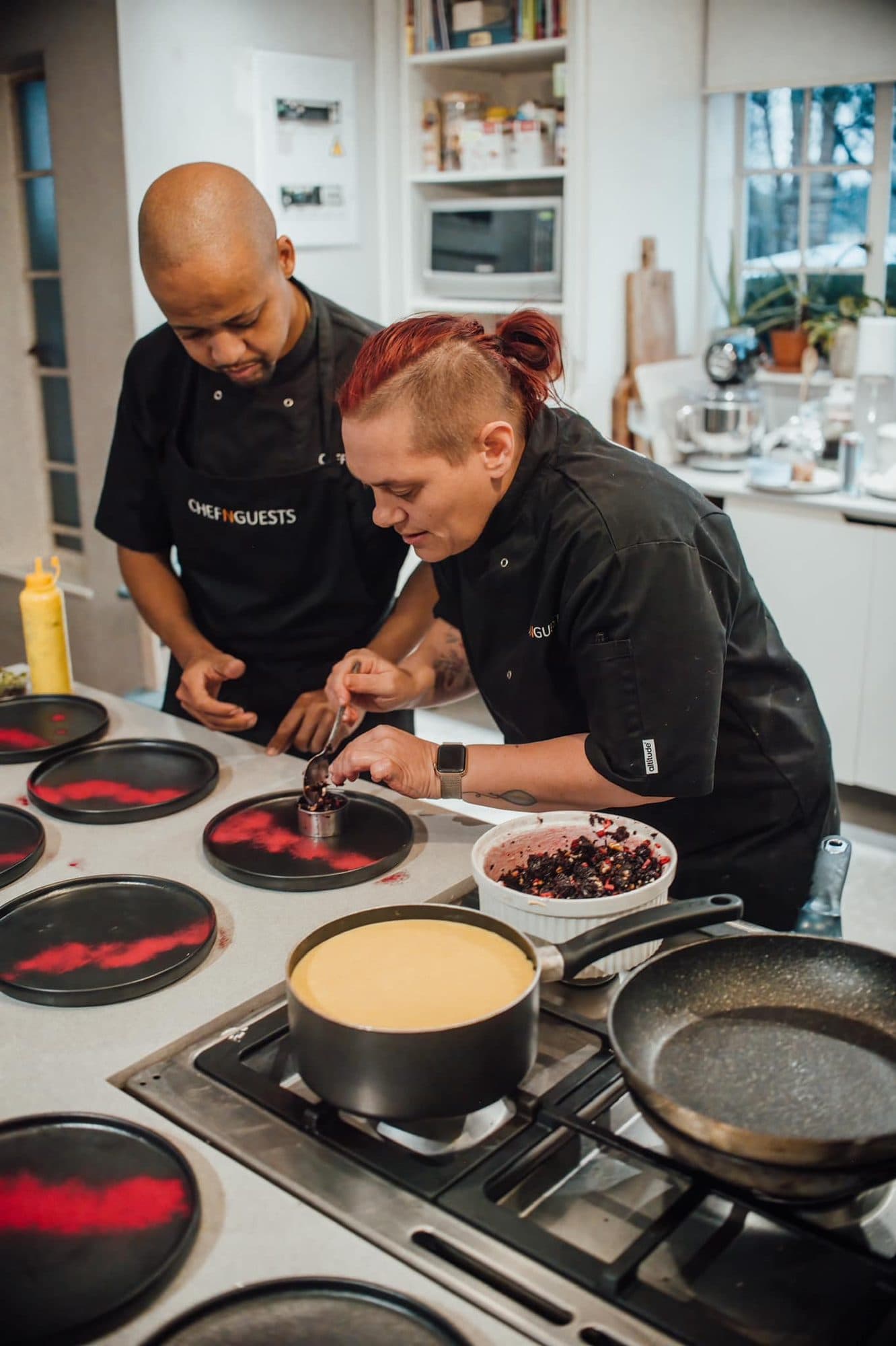 Two chefs cooking side by side at the stove